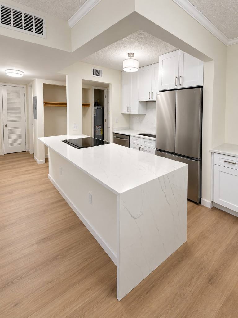 White kitchen remodel with waterfall quartz island